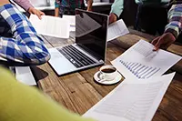 Group collaborating on polished professional presentation design with charts and a laptop, highlighting the importance of brand consistency.