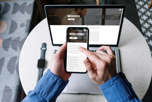 A person previewing a mobile-friendly microlearning course on a laptop and a mobile phone. The course content is visible on both screens, with the laptop screen visible in the background.