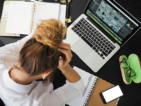 Overhead view of a woman using an AI presentation maker on her laptop to create a pitch deck with presentation templates for investors.