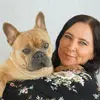 Profile photo of Emilie Dorne, a woman holding a French Bulldog, both looking at the camera.