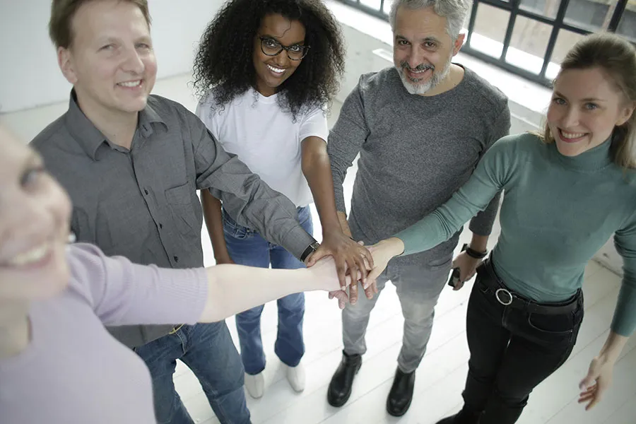 Diverse team showing unity with hands joined together, symbolizing community and collaboration in the hiCreo Community.