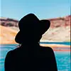 Silhouette of a woman wearing a hat with a scenic background, representing Emily R., Marketing Manager